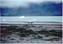 Boeing 727 landet auf der kurzen Piste, kleine Eisberge im Fjord dahinter