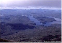 Blick von einem Berggipfel auf die dicht bewaldeten Hgel und den See "Lake Placid"