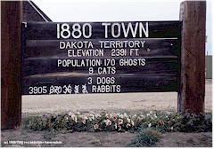 Schild mit Aufschrift: 1880 Town; Dakota Territory; Elevation 2391 Fuss; Population 170 ghosts, 9 cats, 3 dogs, 3905 rabbits