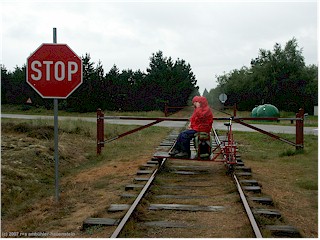 stopptafel und schranken bei einer kreuzung mit einer strasse