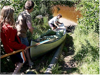 katrin, reto und daniel schieben das kanu bei der portage