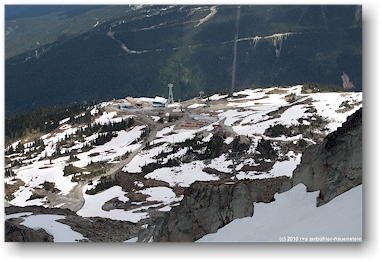 blick vom whistler mountain auf die geparkten pistenfahrzeuge bei der roundhouse lodge