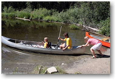 katrin schiebt das kanu mit mathias und daniel in den kibbee lake