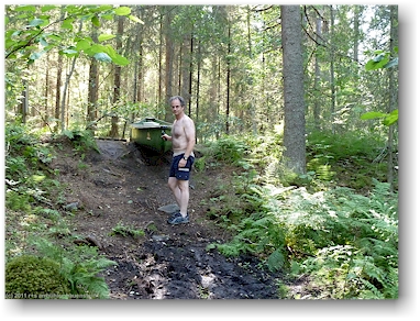 reto schleppt unser kanu ueber den kleinen damm vom floesser kanal zum fluss karijoki auf der eichhoernchen-route (oravareitti) zwischen juva und sulkava, FI