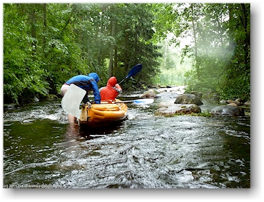 katrin und mathias haengen mit ihrem schlauchboot an einer untiefe auf dem kyrsyaenjoki, teil der eichhoernchen-route (oravareitti) zwischen juva und sulkava, FI