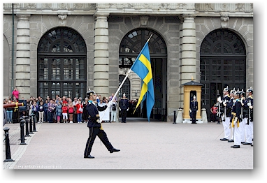 der fahnentraeger praesentiert die fahne bei der wachabloesung im innenhof des koenigsschlosses in stockholm, SE