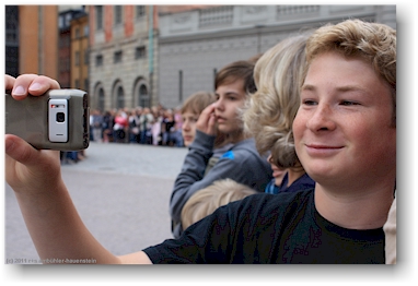 mathias filmt mit seinem handy die wachabloesung im innenhof des koenigsschlosses in stockholm, SE