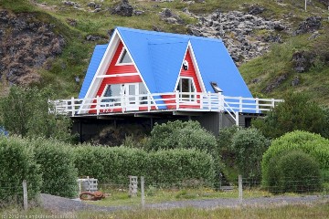 blau, weiss und rotes haus an der kueste bei hellnar