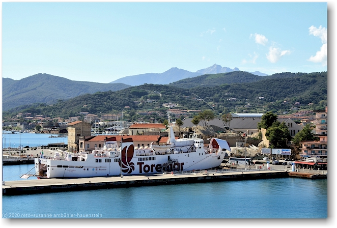 blick von der porta a terra auf eine faehre im hafen von portoferraio mit dem monte capanne im hintergrund