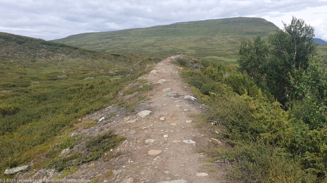 wanderweg ueber einen kleinen damm am fuss des gruvvalen