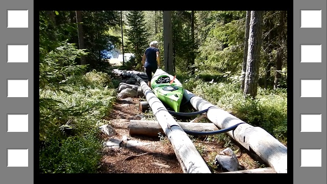susanne schleppt ihr kajak ueber die bootrutsche zum ala-oelkky hinunter im hossa nationalpark (film)