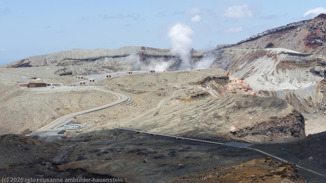 wandersteg durch die ebene sunasenri mit menschenleerer aussichtsplattform beim nakadake krater